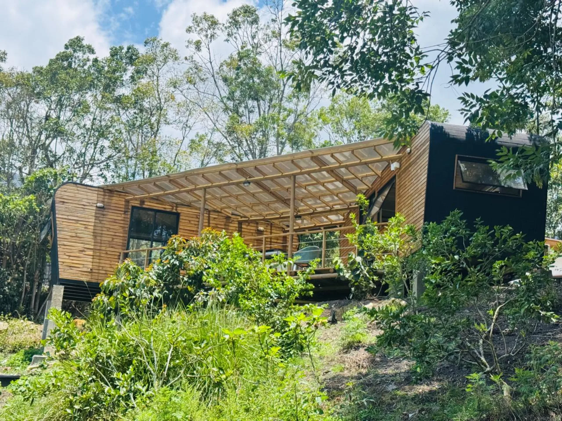 Modhaus instalado en entorno boscoso con pérgola exterior